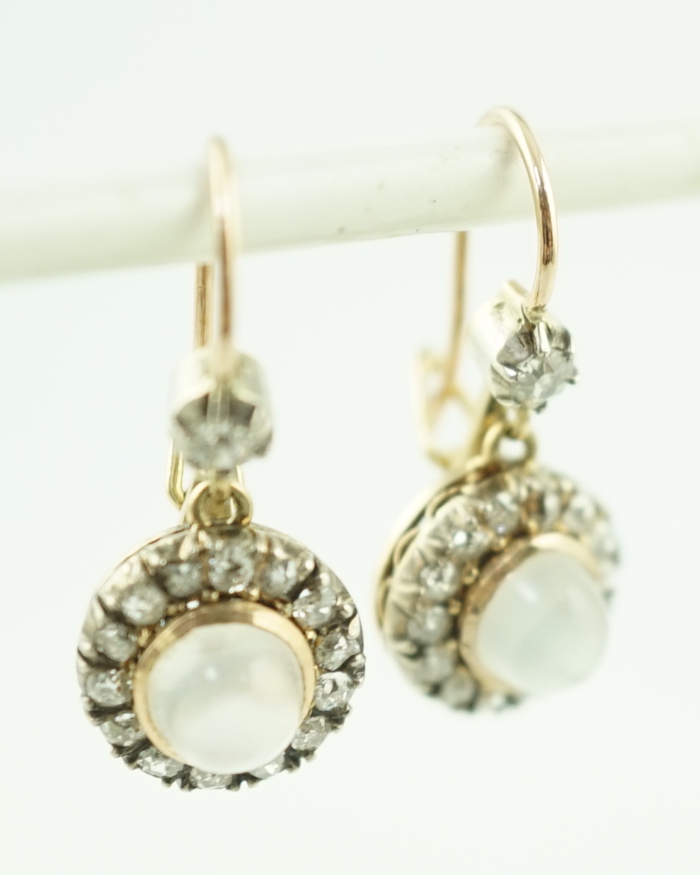 A pair of early 20th century gold, moonstone and old round cut diamond set cluster drop earrings